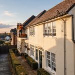 Roofer inspecting frosted clay roof tiles on a Surrey home before winter.